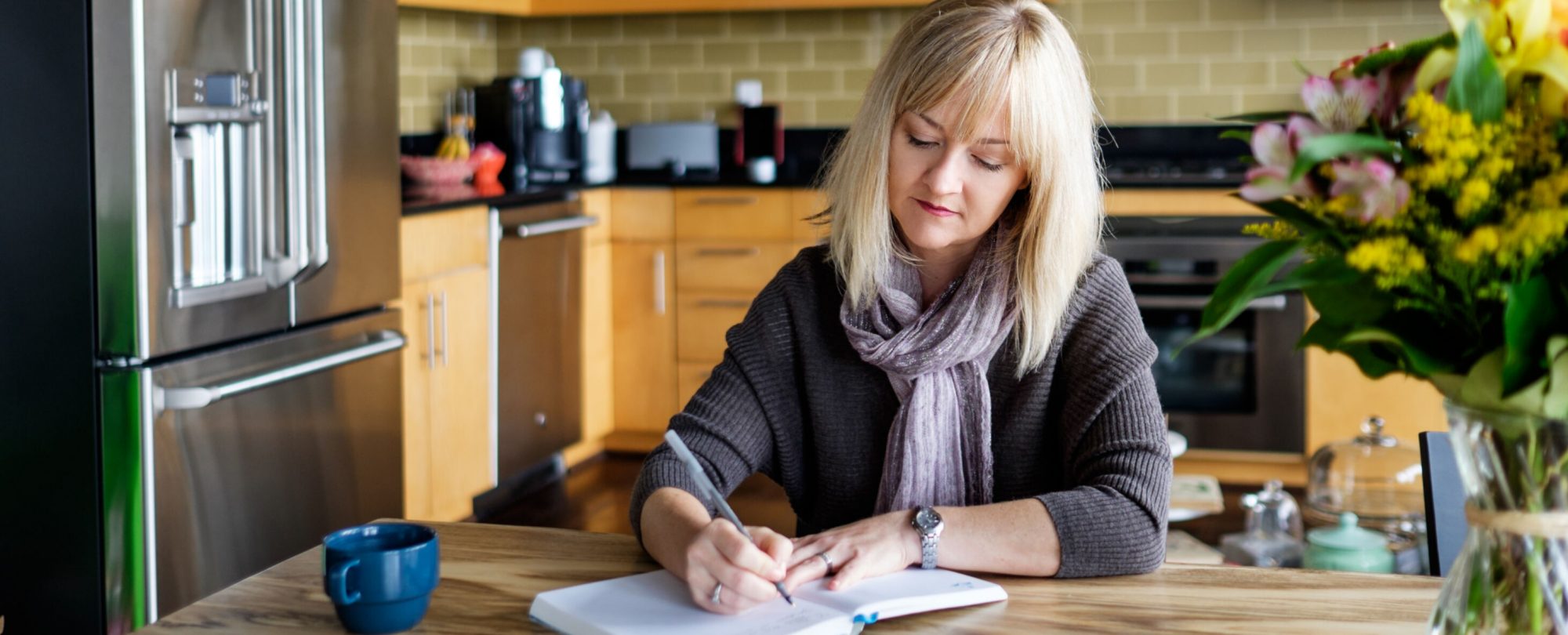 Woman Writing On A Notebook At Home