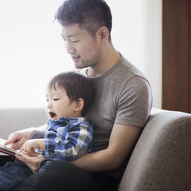 Father and son reading a book together