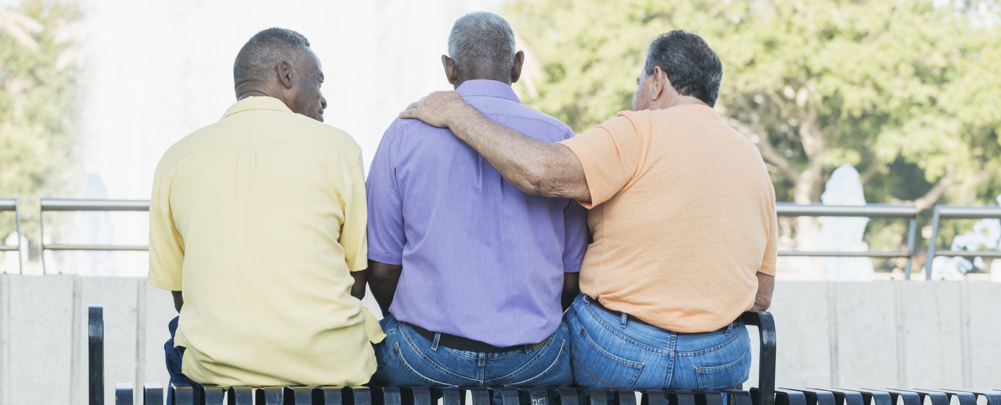 Three multi-ethnic senior men sitting on bench