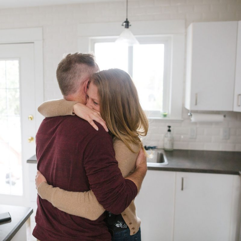 Serious Couple Hugging Together At Home.